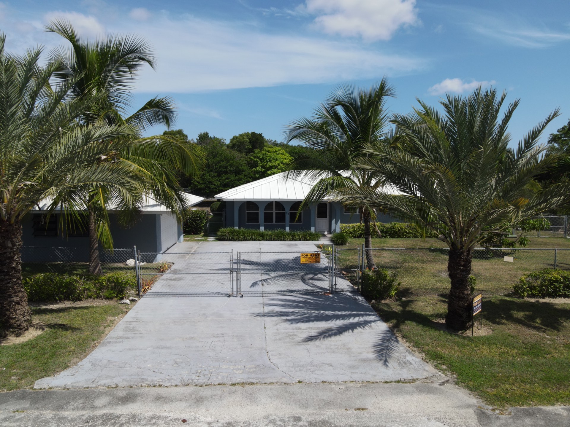Blue custom home with white standing-seam metal roof, Grand Bahama