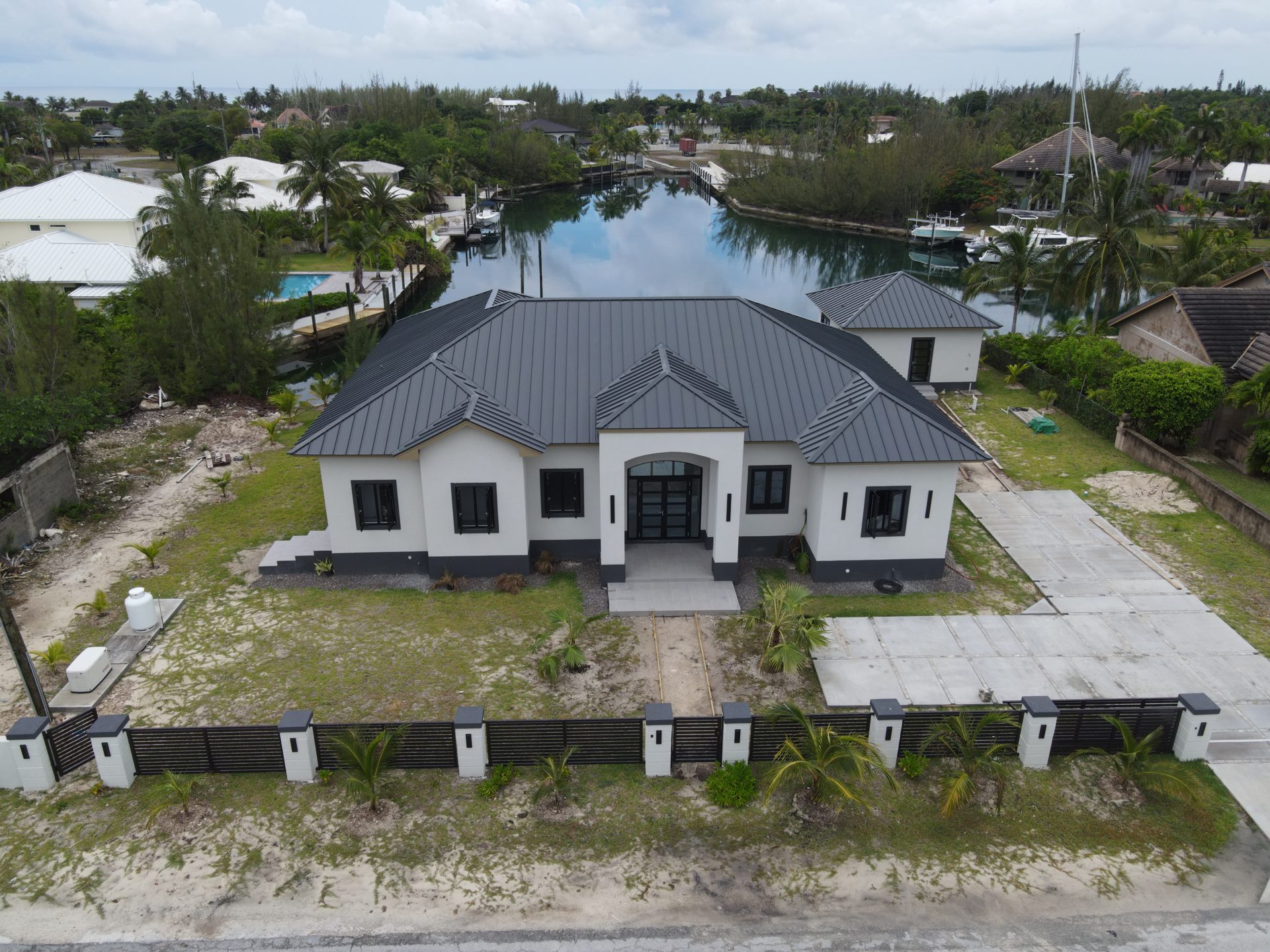 Recently completed modern canal-front home with standing-seam metal roof in Grand Bahama